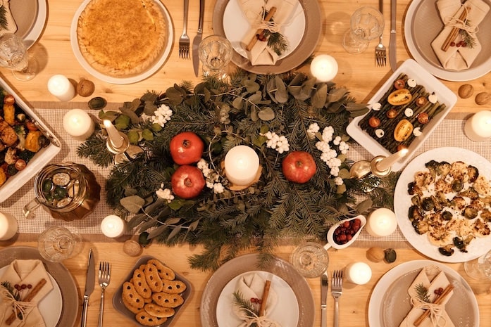 A dining table with Christmas decorations and plates of festive food